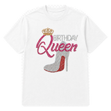 A white short-sleeve t-shirt with a rhinestone-style graphic on the front that reads 'BIRTHDAY Queen' with a crown and a high-heeled shoe in pink, silver, and red tones.