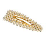 A gold-tone hair clip embellished with multiple rows of small white faux pearls, shown on a transparent checkered background.