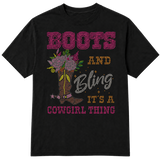A black short-sleeve t-shirt with a western-themed rhinestone-style graphic that reads 'BOOTS AND Bling IT'S A COWGIRL THING' in pink, gold, and silver lettering, alongside an illustration of a cowboy boot decorated with flowers on a transparent background.