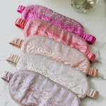 Set of rhinestone eye masks with rhinestone embellishments on a marble surface.