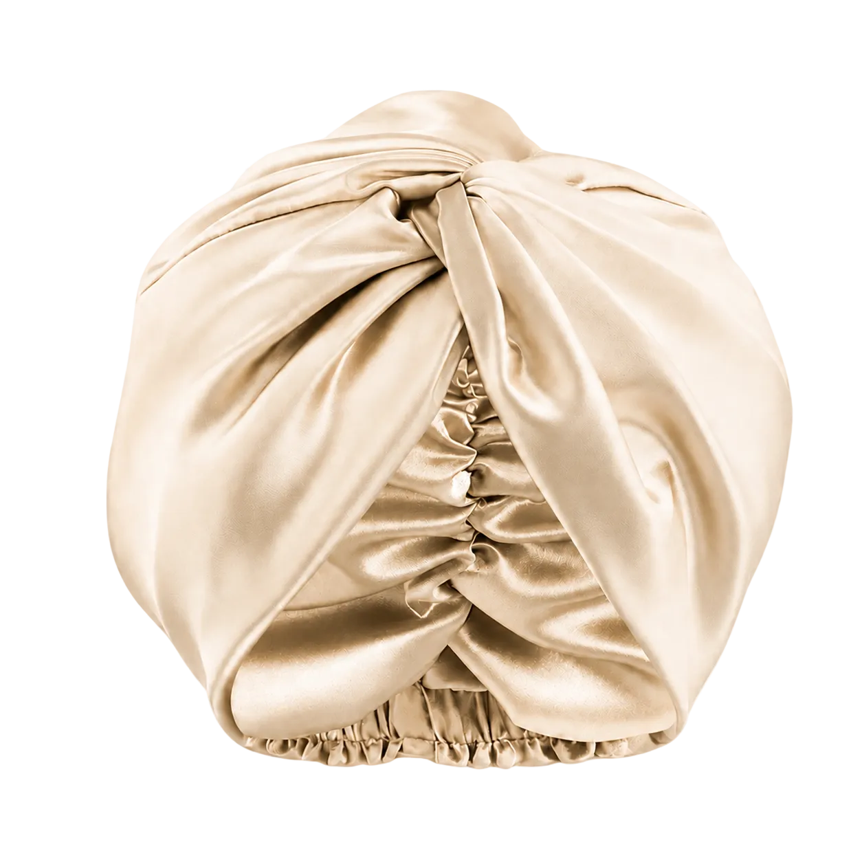 A champagne color mulberry silk turban headwrap with a knotted top and gathered elastic bottom, shown on a transparent checkered background.