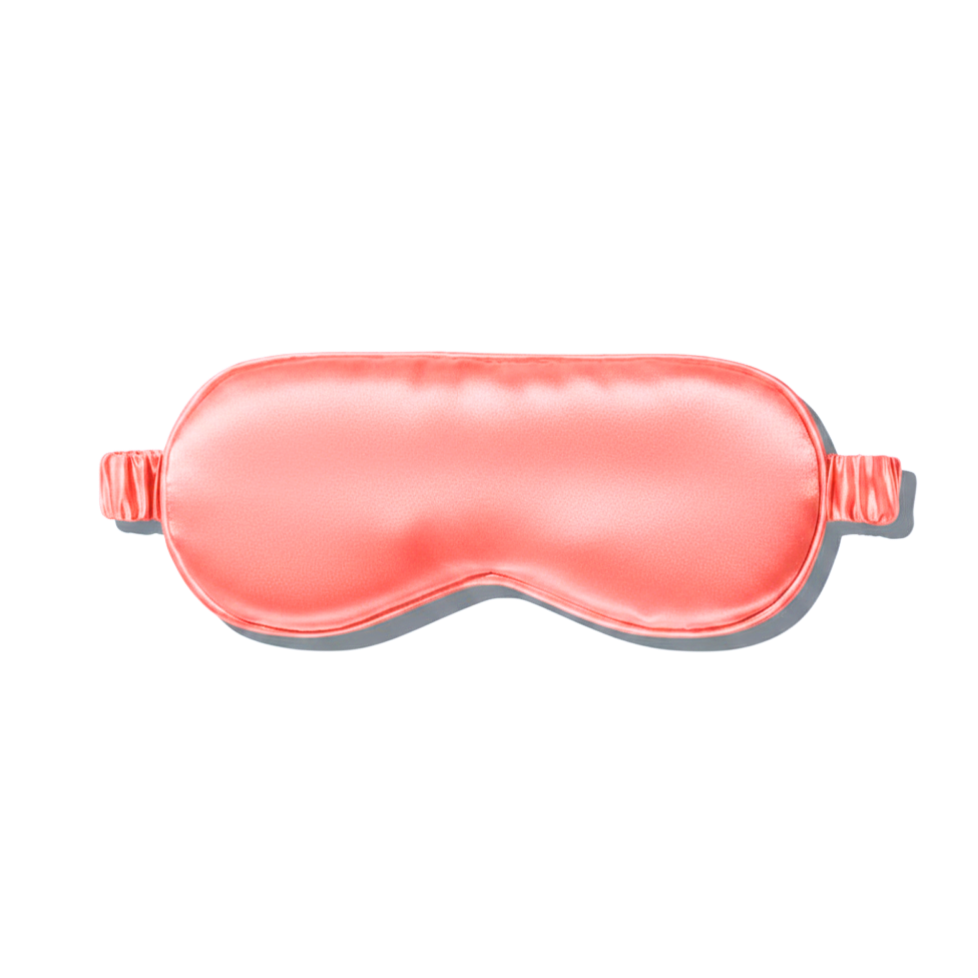 A coral pink mulberry silk sleep mask shown on a clean white background with a soft drop shadow.