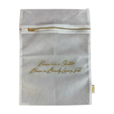 White mesh bag with gold zipper and text on a white background