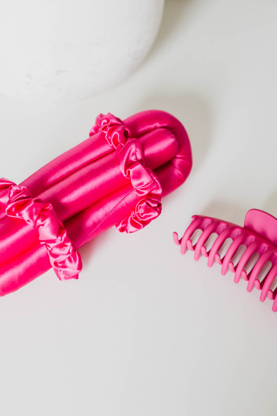 Hot pink Brindy Mulberry Silk heatless hair roller set with a claw clip and a white background