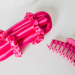 Hot pink Brindy Mulberry Silk heatless hair roller set with a claw clip and a white background