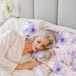 Model sleeping on a purple floral pillowcase  in a champagne robe