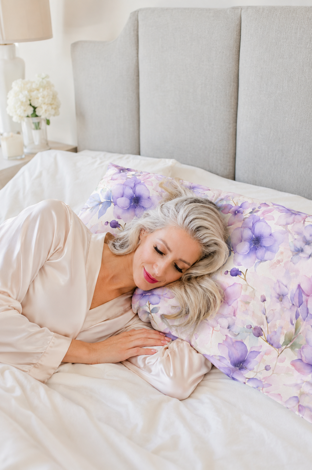 Model sleeping on a purple floral pillowcase  in a champagne robe