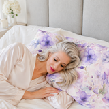 Model sleeping on a purple floral pillowcase  in a champagne robe