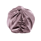 A dusty mauve mulberry silk turban-style headwrap or bonnet with gathered ruching and an elasticized bottom, shown on a transparent checkerboard background.
