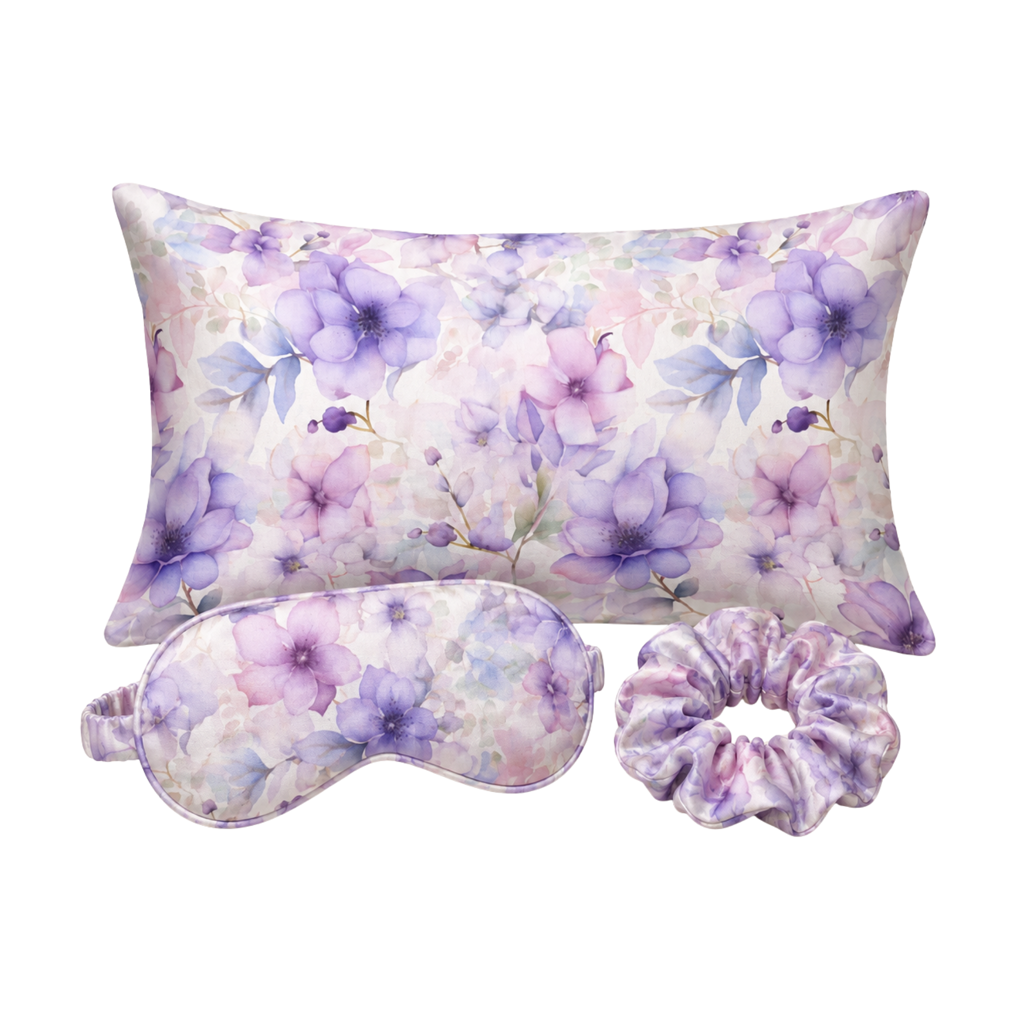 A floral mulberry silk pillow set on a white background, including a rectangular pillow, a matching eye mask, and a purple-toned scrunchie. The fabric features a watercolor-style print of purple flowers and blue leaves on a soft lavender and pink base.