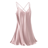 A rose pink mulberry silk slip dress with thin crisscross spaghetti straps and a V-neckline, shown against a transparent checkered background.